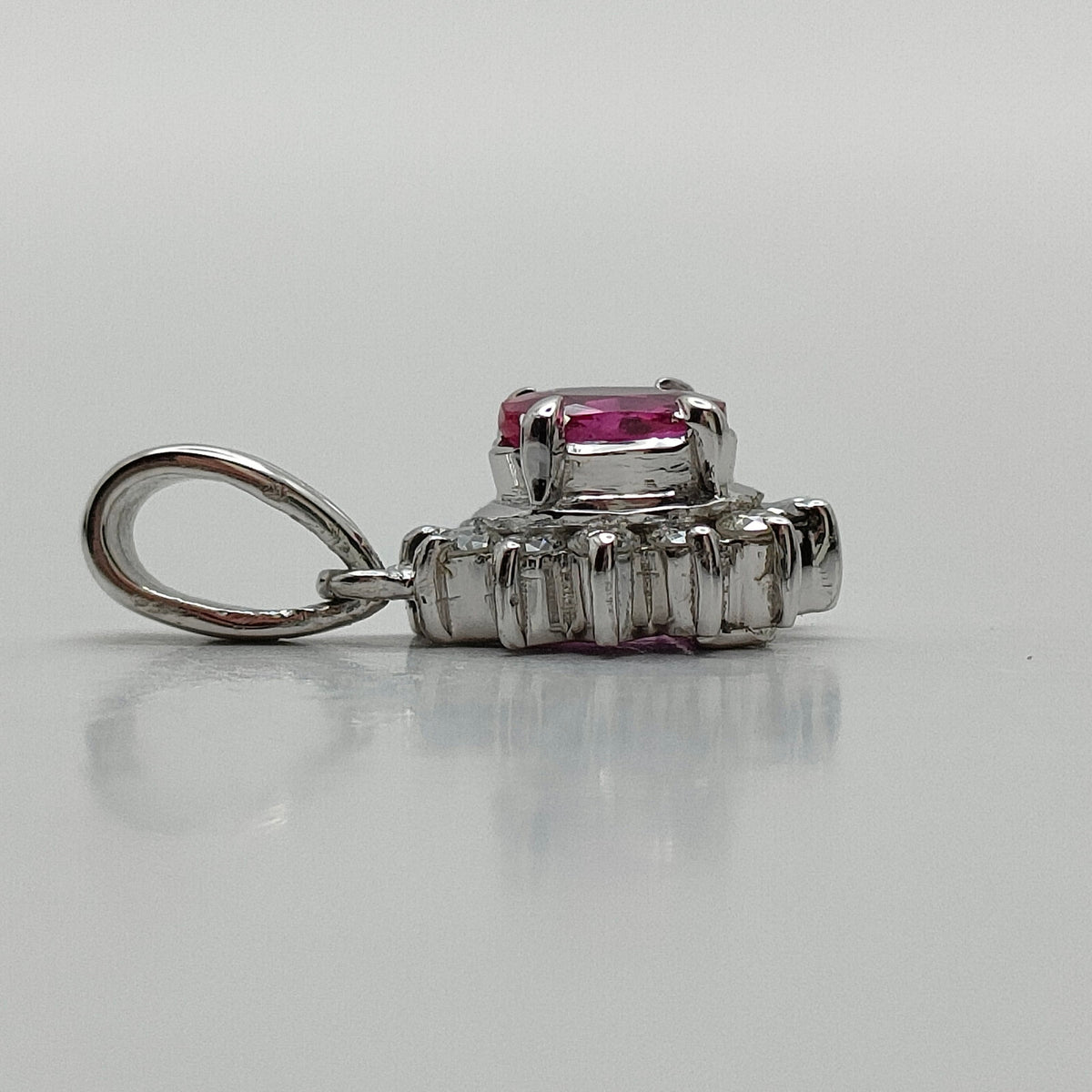 Platinum ruby and diamond halo pendant side