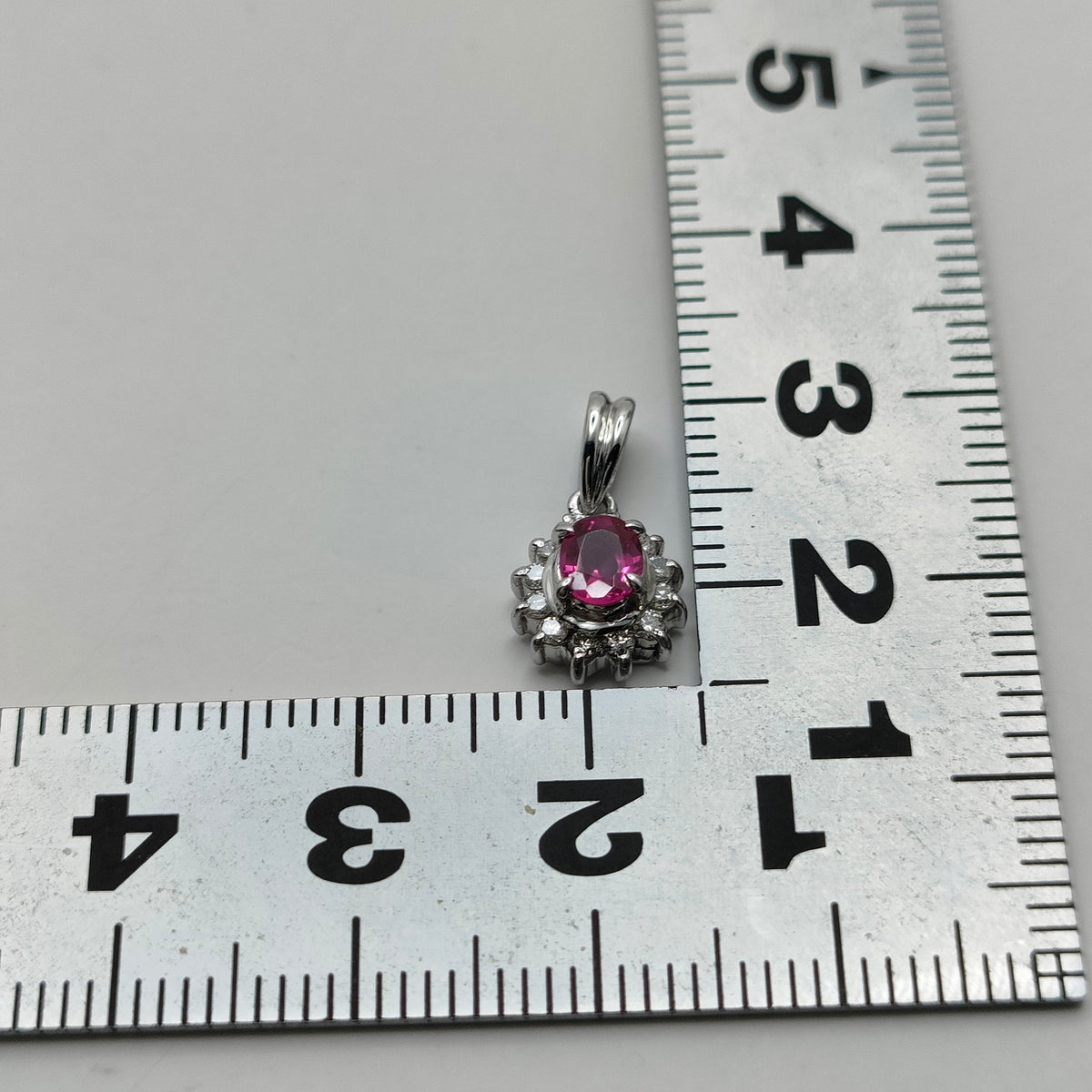 Platinum ruby and diamond halo pendant ruler