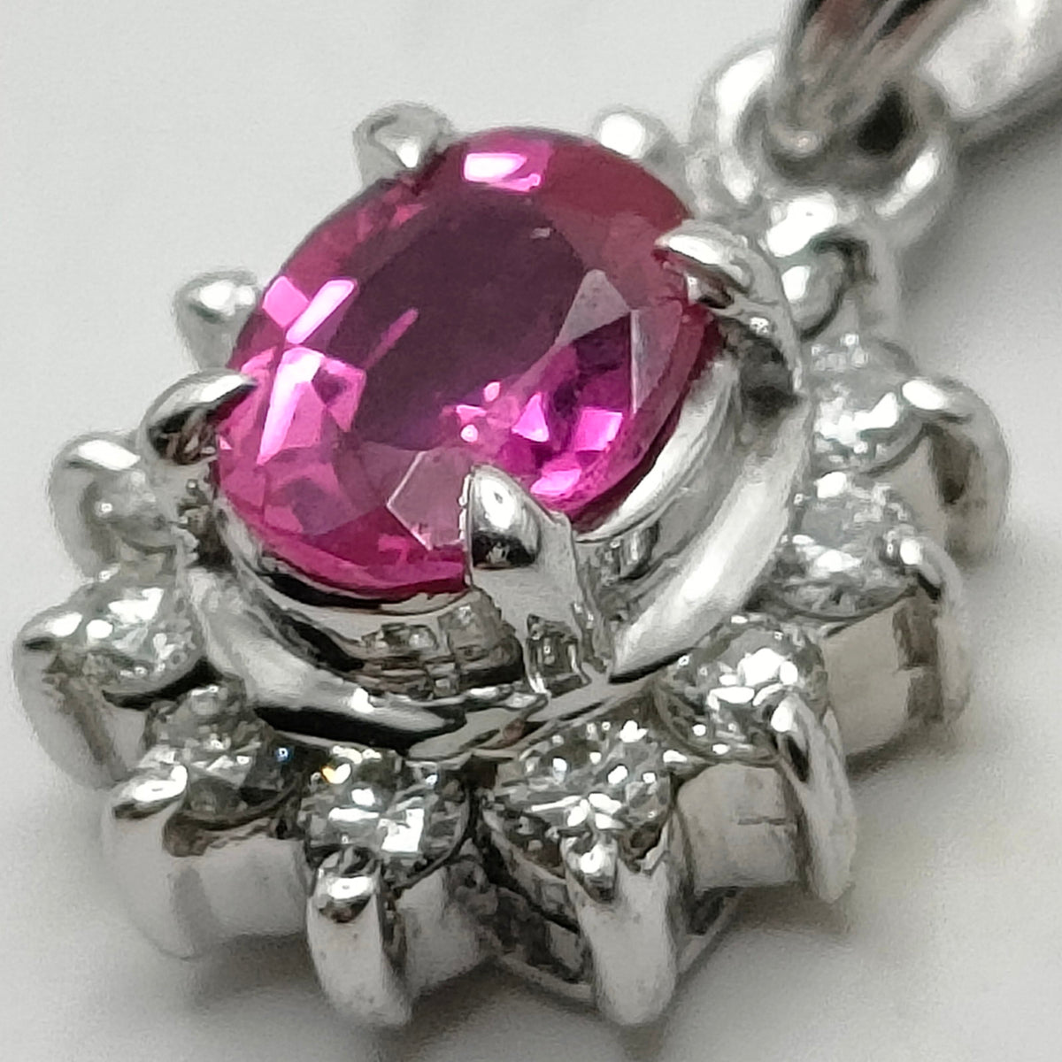 Platinum ruby and diamond halo pendant stone detail